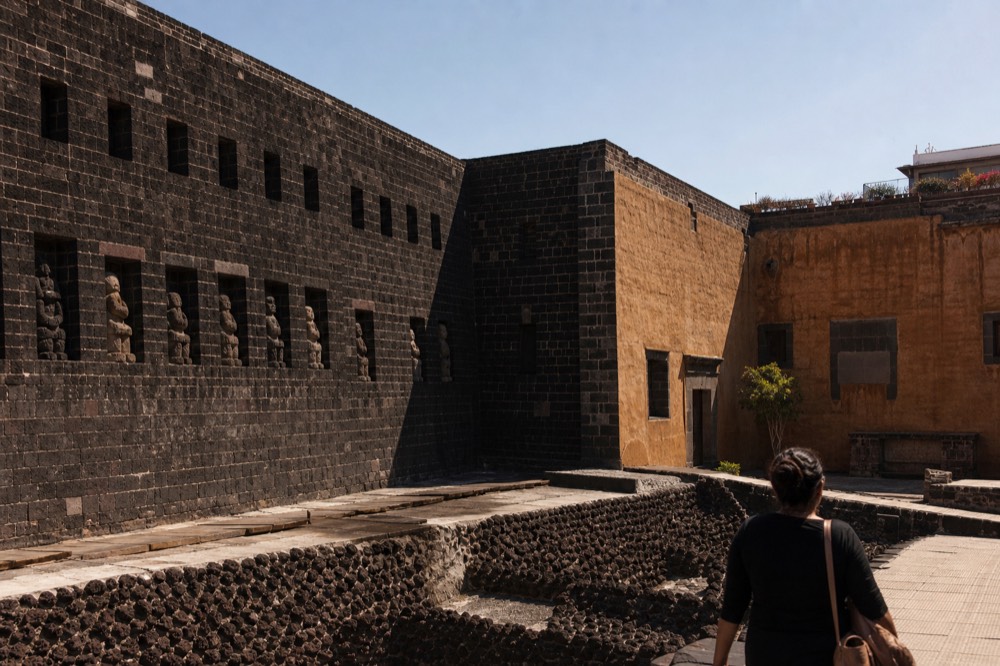 The dark volcanic-stone facade of Museo Anahuacalli rising like a temple against the sky